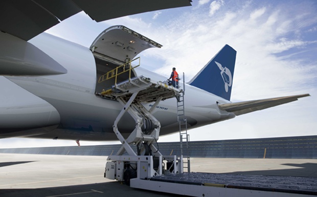 an airplane is being loaded with luggage by a man on a ladder near the wing