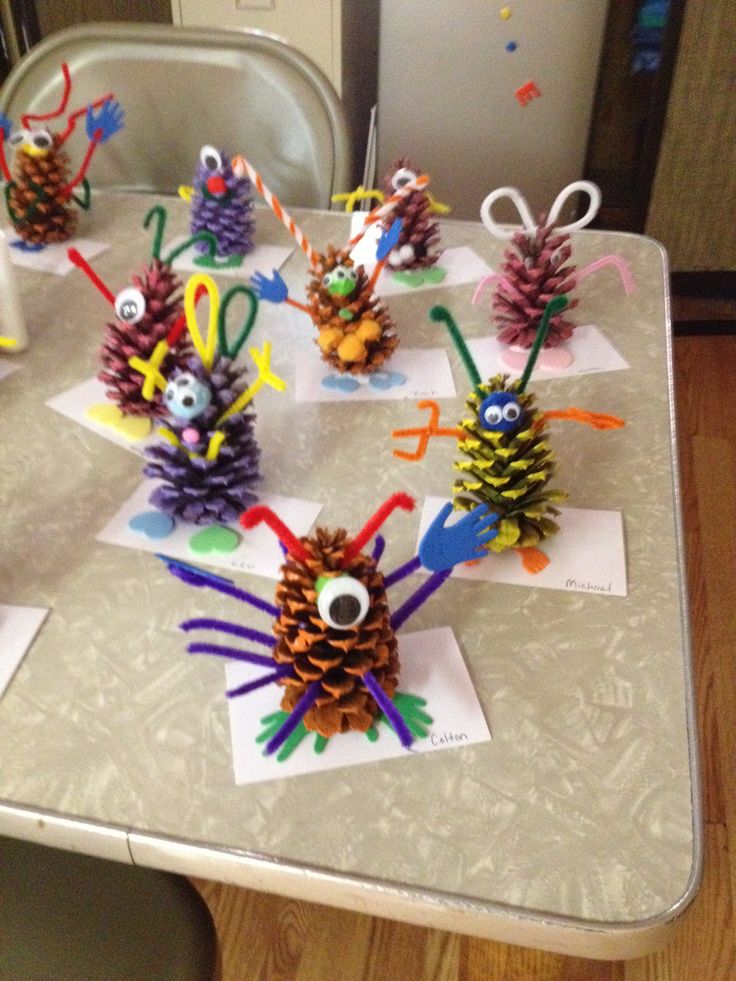 some pine cones are sitting on top of a table with paper and scissors in them