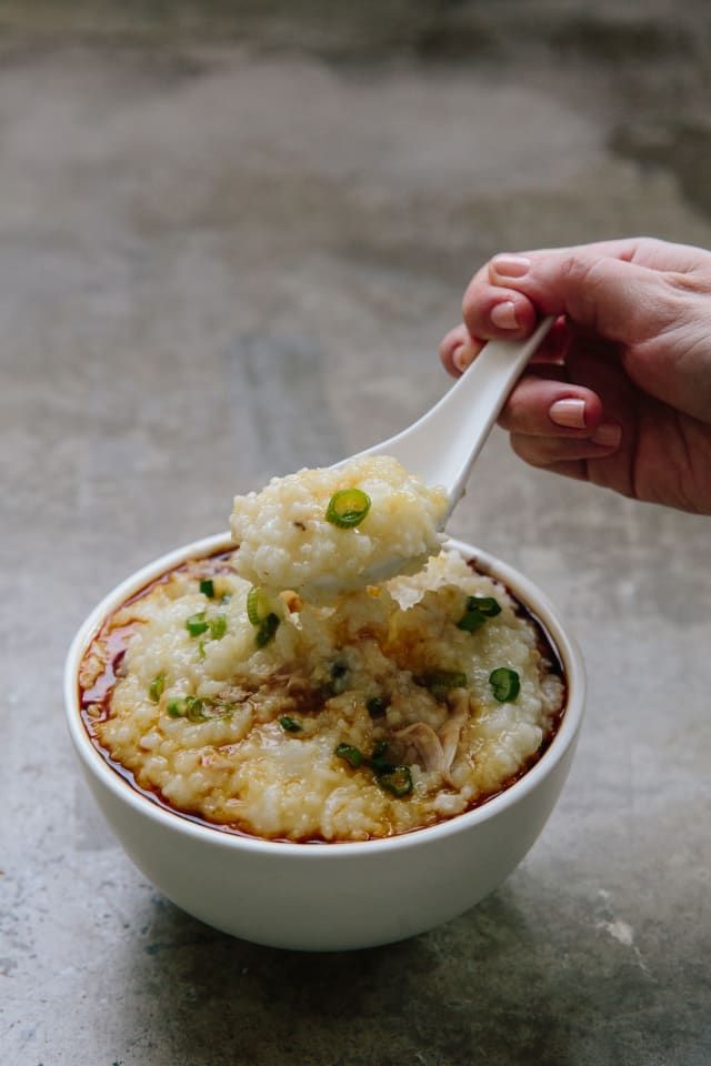 a hand holding a spoon full of mashed potatoes