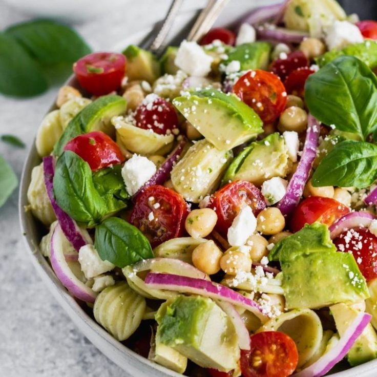 a salad with tomatoes, avocado, lettuce and chickpeas