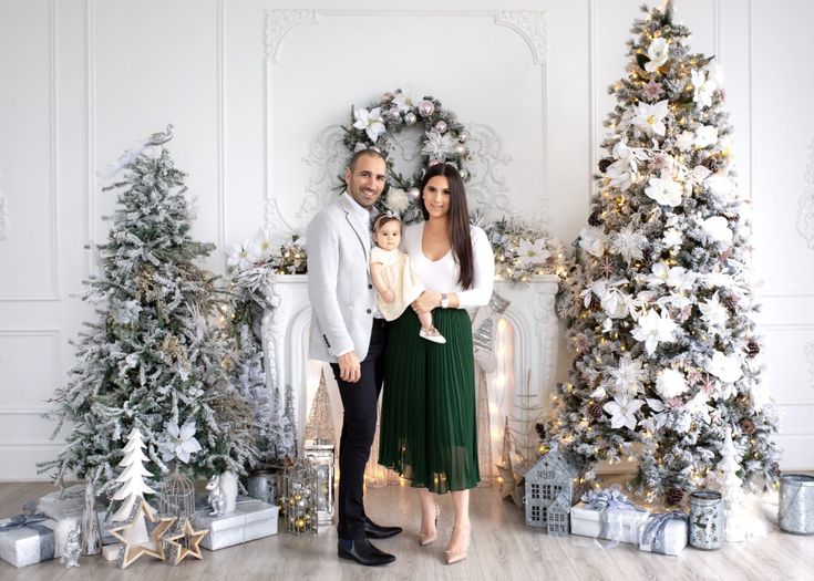 a man and woman standing in front of christmas trees