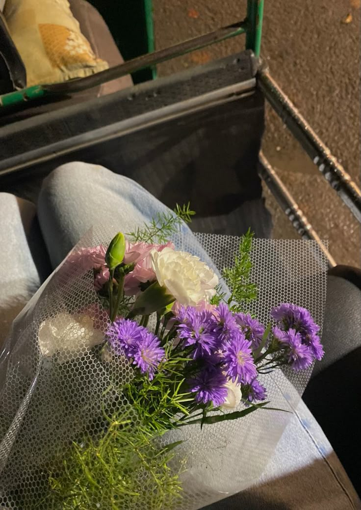 purple and white flowers are placed in the back of a truck's passenger seat