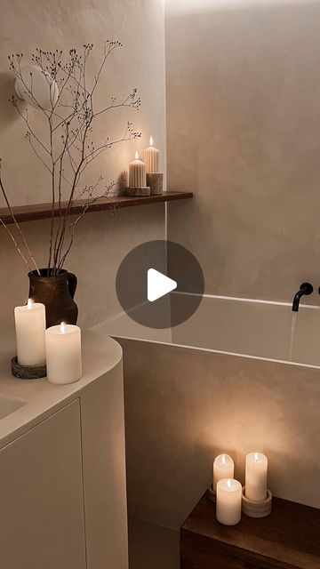 a bathroom with candles on the counter and in the bathtub