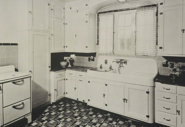 an old black and white photo of a kitchen with checkered flooring on the tiles