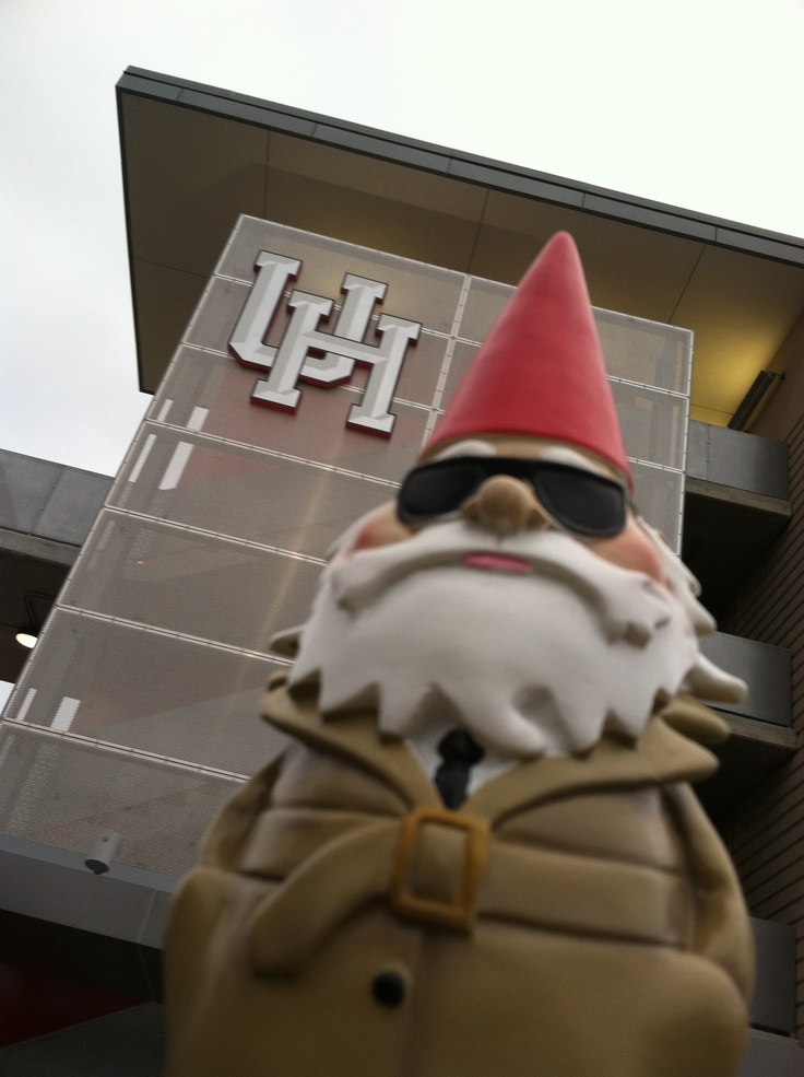 a statue of a man with a red hat and sunglasses is in front of a building