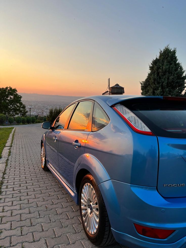 a blue car parked on the side of a road