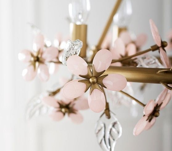 a chandelier with pink flowers hanging from it's sides and gold accents