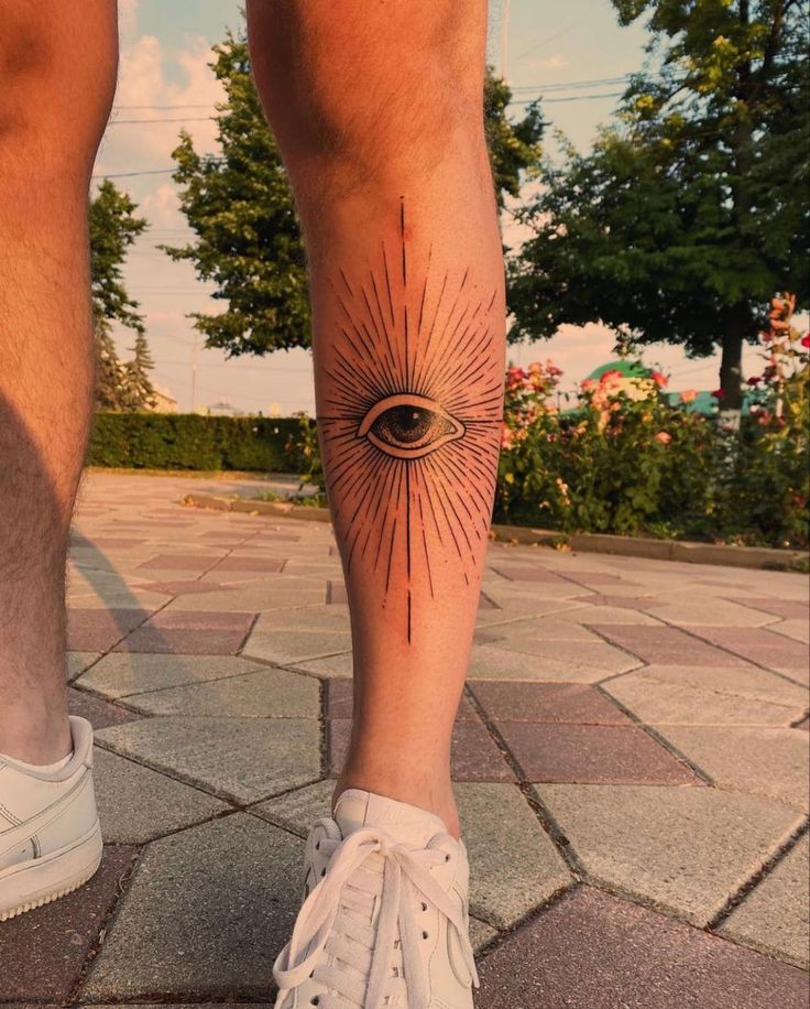 a man's leg with an eye tattoo on it