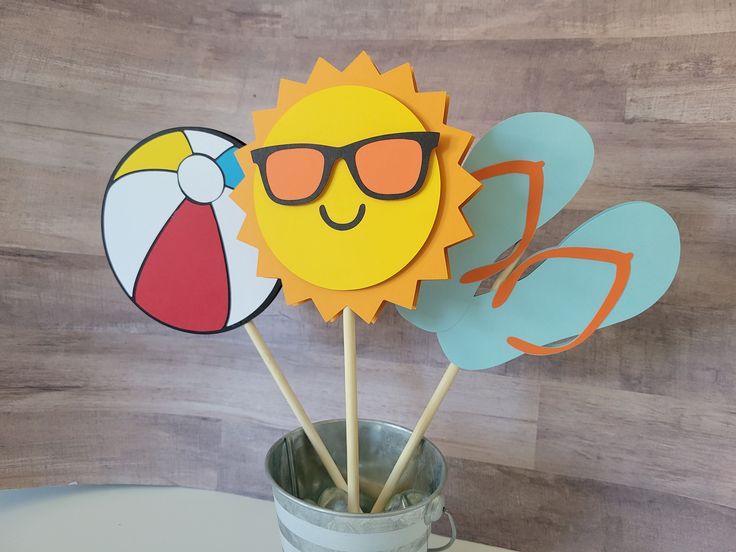 the sun and sunglasses are on top of each other in a cup with toothpicks