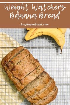 a loaf of banana bread sitting on top of a cooling rack next to a bunch of bananas