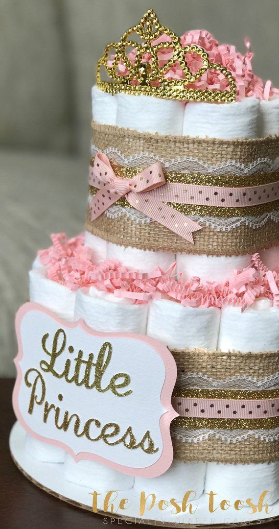 a little princess diaper cake with pink and gold trimmings on the top