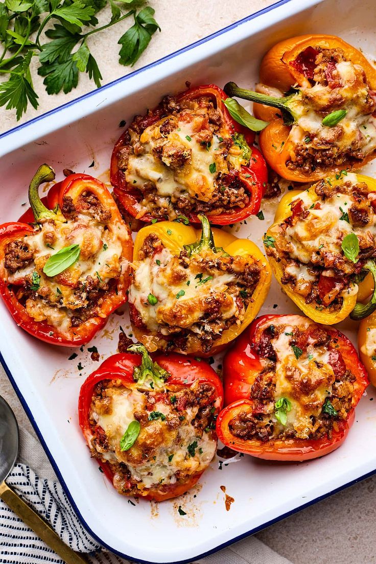 stuffed bell peppers in a casserole dish with parsley on the side, ready to be eaten