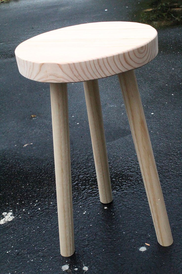 a wooden stool sitting on top of a wet ground