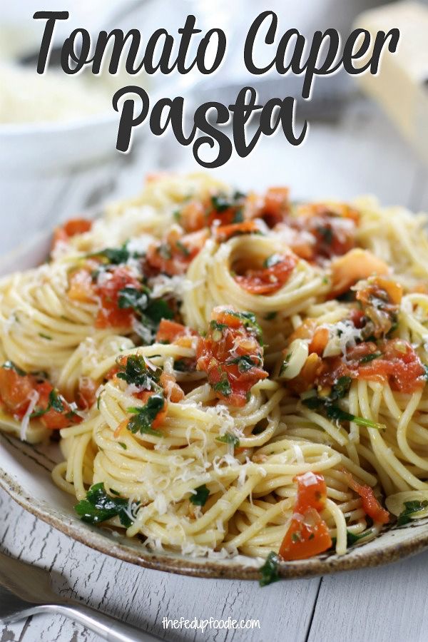 a white plate topped with pasta covered in tomato sauce