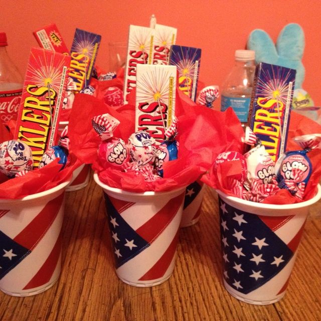 three buckets filled with candy on top of a wooden table