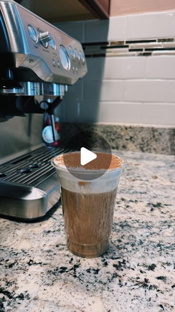 a coffee cup sitting on top of a counter next to an espresso machine