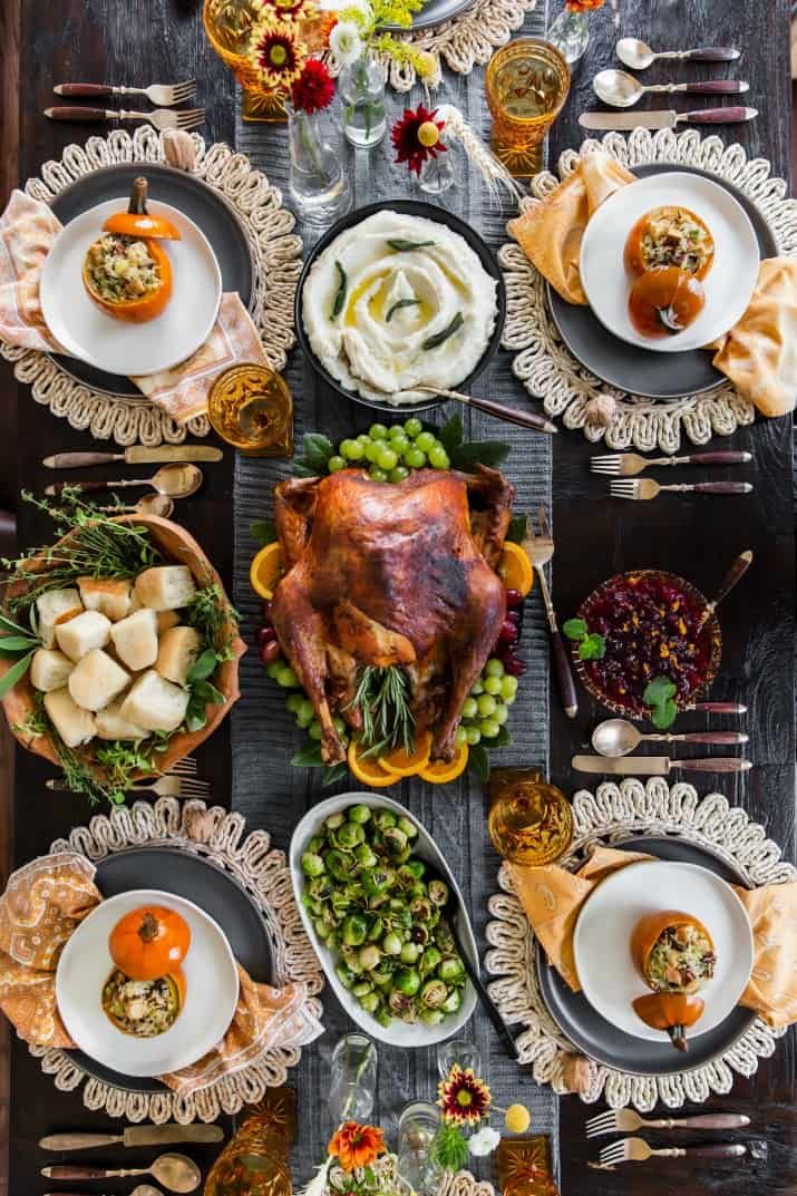 an overhead view of a thanksgiving table setting with turkey, vegetables and other food items