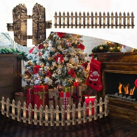 a christmas tree with presents under it in front of a fire place and wooden fence