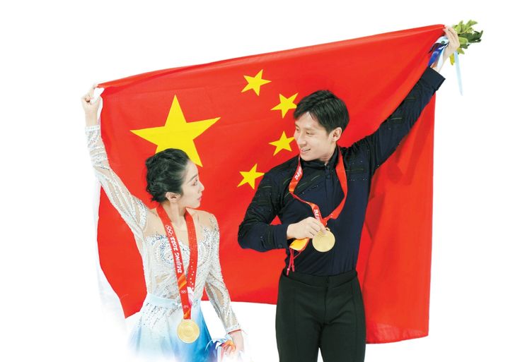 a man and woman standing next to each other in front of a flag with medals