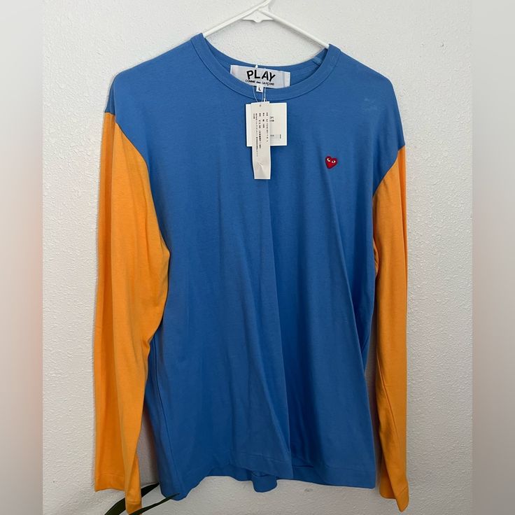 Comme Des Garons Long Sleeve Tshirt. New With Tag Casual Blue Color Block Shirt, Orange Long Sleeve Tops With Graphic Print, Orange Long Sleeve Top With Graphic Print, Orange Color Block Tops For Fall, Fall Orange Color Block Tops, Blue T-shirt For Fall Streetwear, Orange Long Sleeve T-shirt With Graphic Print, Orange Long Sleeve Graphic T-shirt, Spring Blue Color Block T-shirt