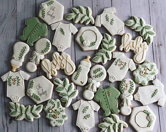 decorated cookies with green and white designs are arranged on a wooden table, ready to be eaten