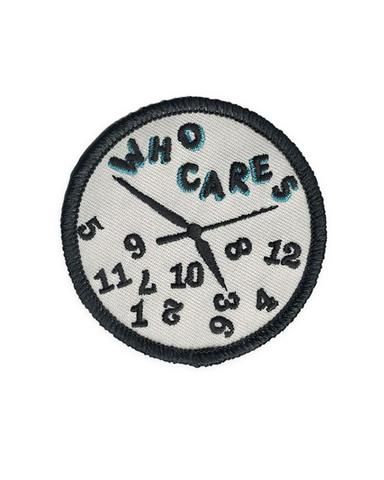 a white and black patch with the words who cares on it's face in blue letters