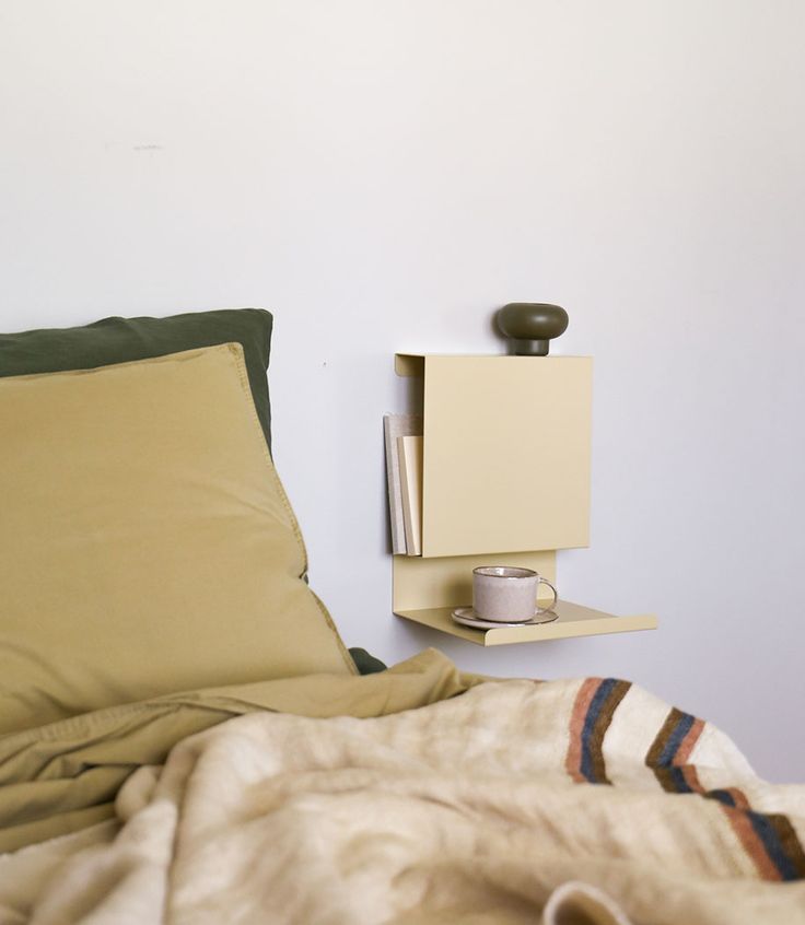 a bedroom with a bed, night stand and pillow on the floor next to it