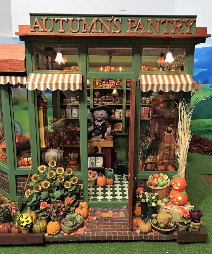 an autumn's pantry display with pumpkins, squash and other items in it