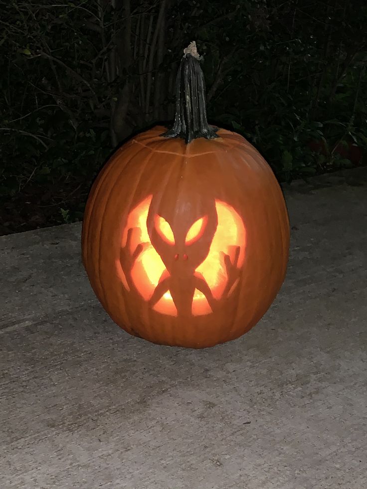 a carved pumpkin with an image of a demon on it