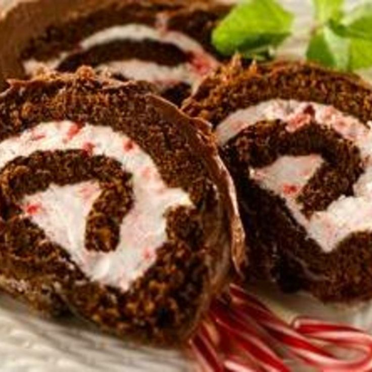 chocolate roll with white frosting and peppermink on it sitting on a plate