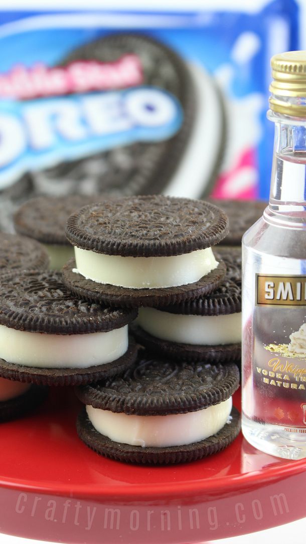 an oreo sandwich and some ice cream on a red plate with a bottle of soda