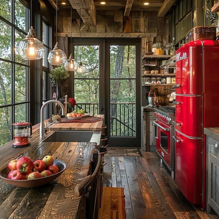 a red refrigerator sitting inside of a kitchen next to a wooden table and stove top oven