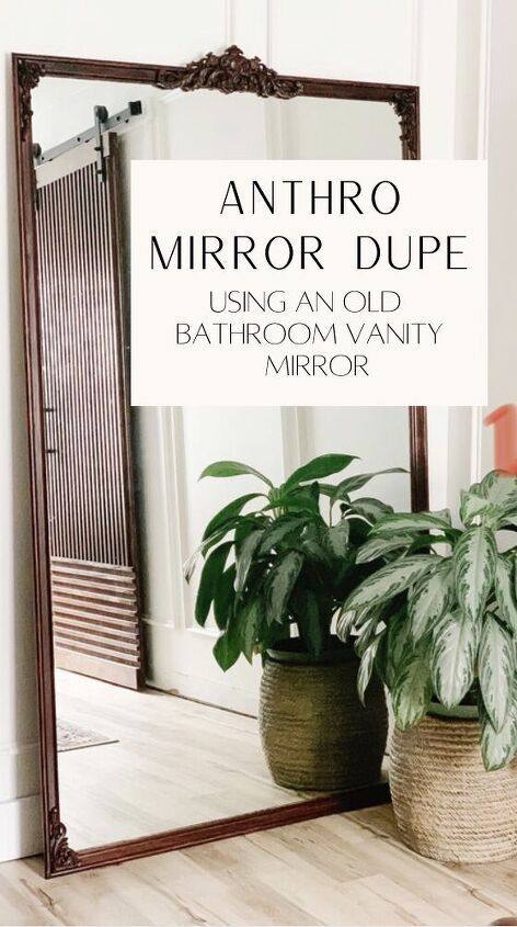 a mirror sitting on top of a wooden floor next to two potted planters