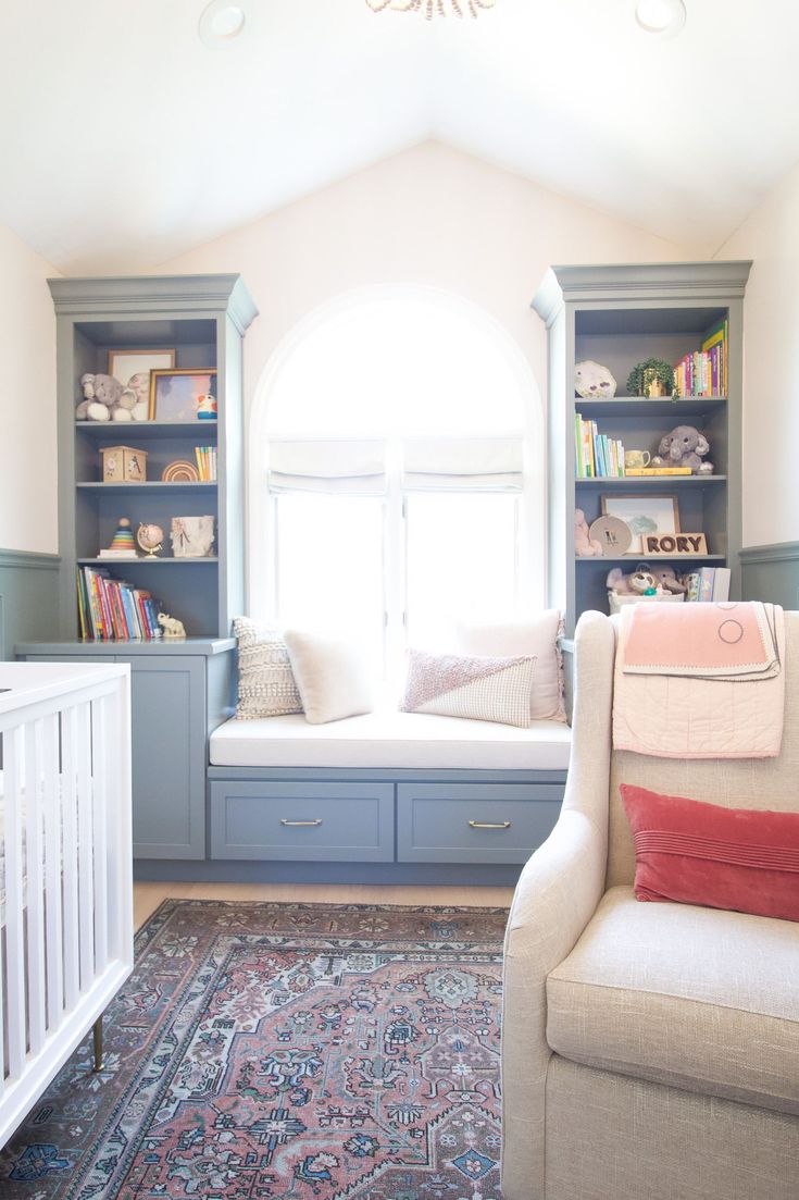 a baby's room with a white crib and blue built in bookshelves