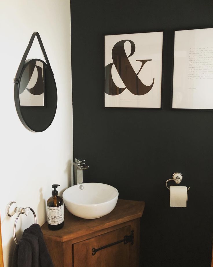 a bathroom with two pictures on the wall and a white sink in front of it