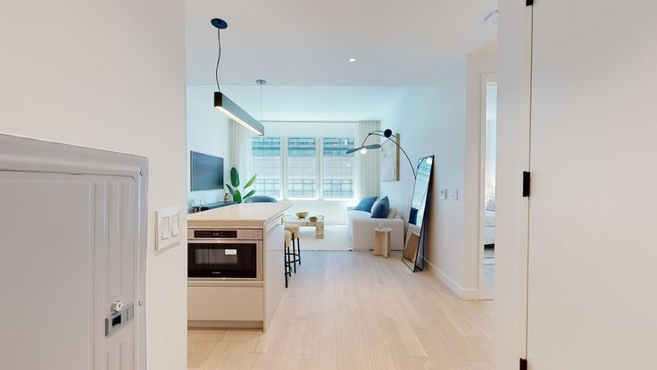 an open door leading to a kitchen and living room in a house with white walls