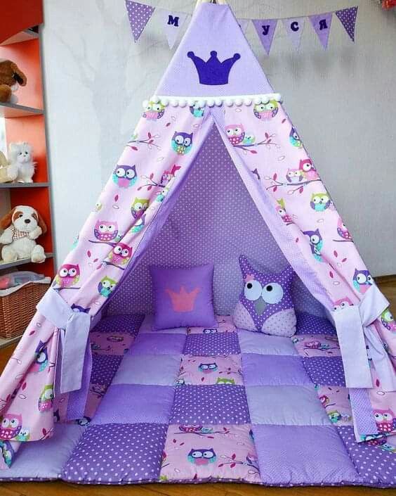 a child's teepee tent with owls and purple polka dots on the floor