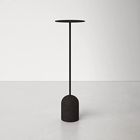 a black table with a round base on the top and a metal pole in the middle