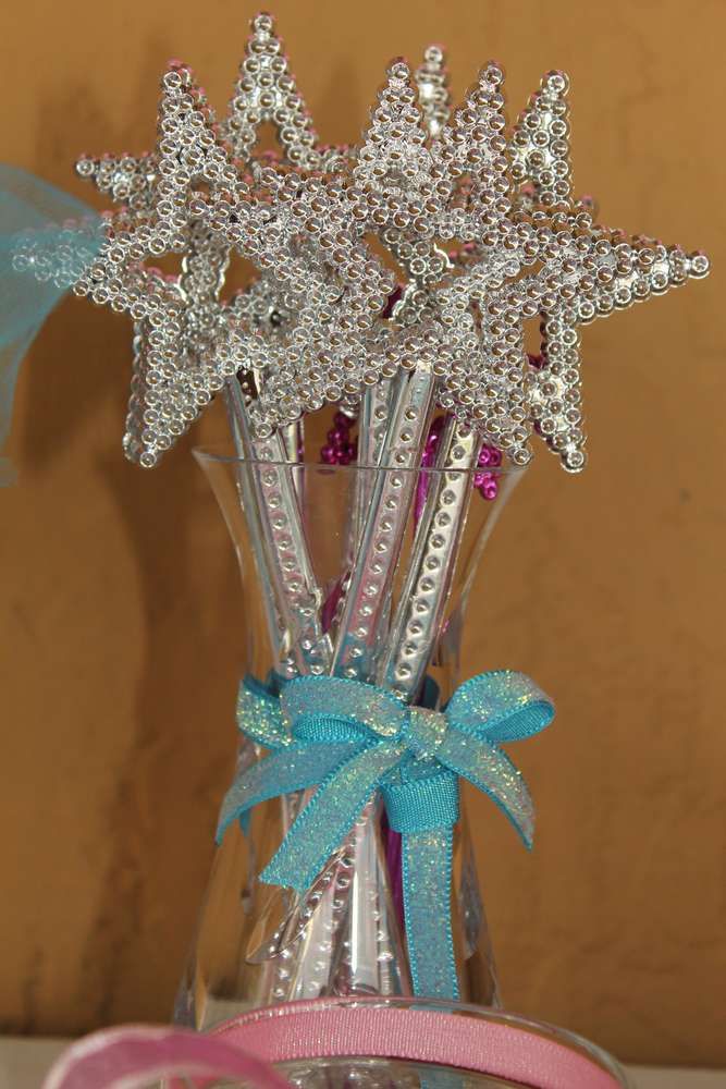 three star shaped toothbrushes in a clear glass vase with pink and blue ribbon