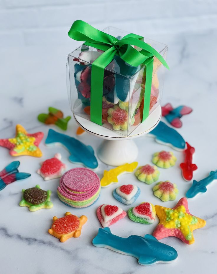 a box filled with lots of colorful candies on top of a white marble counter