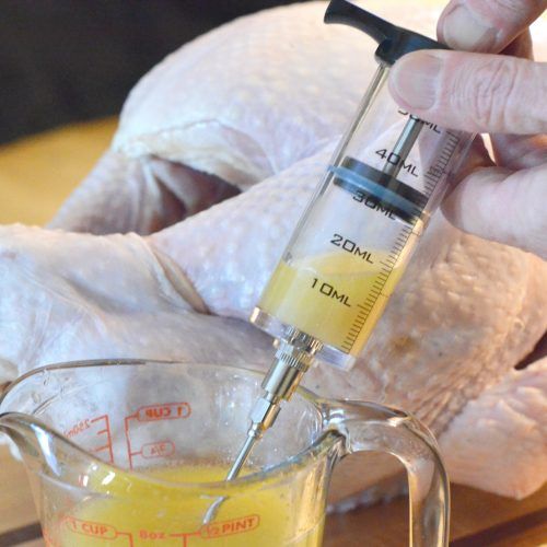 a person is holding a thermometer in front of a turkey and measuring it