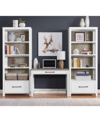 a computer desk and bookcases in a room with blue walls, white furniture and wooden flooring