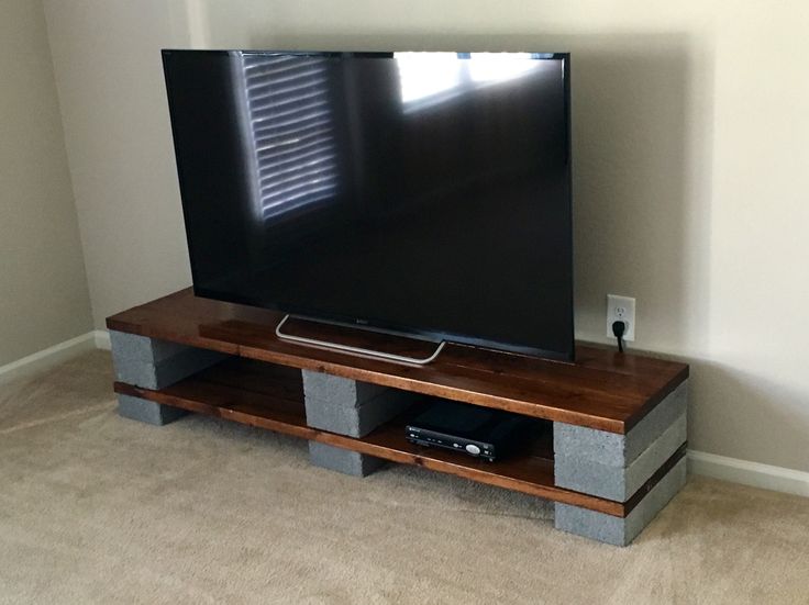 a flat screen tv sitting on top of a wooden entertainment center in a living room