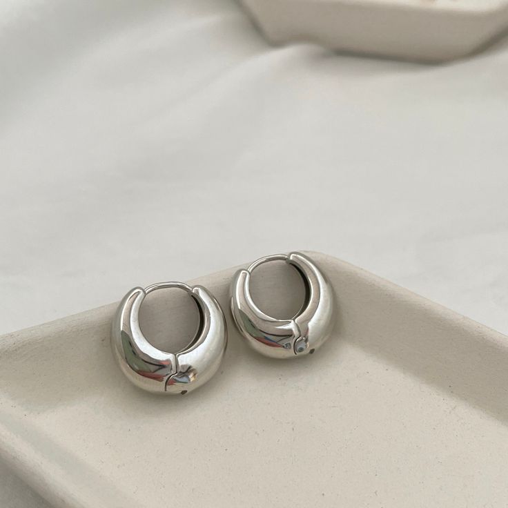 Upgrade your earring game with our Chubby Huggie Hoop earrings. These hoops are sure to make a statement with their timeless design and sturdy build. Perfect for everyday wear and a must-have for any jewelry collection. From sunrise to sundown, these will become a favorite! Details: 14kt gold plated over stainless steel or silver plated 15mm hoops Trendy Small Hoop Sterling Silver Huggie Earrings, Trendy Small Hoop Huggie Earrings In Sterling Silver, Trendy Sterling Silver Small Hoop Huggie Earrings, Trendy Everyday Metal Cartilage Earrings, Trendy Metal Huggie Earrings, Everyday Silver Metal Huggie Earrings, Everyday Metal Cartilage Earrings Pair, Trendy Small Hoop Metal Earrings, Trendy Metal Hoop Earrings For Everyday