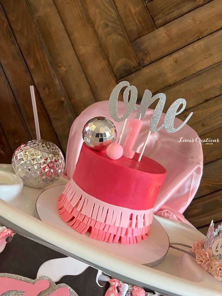 a cake with pink frosting and silver decorations