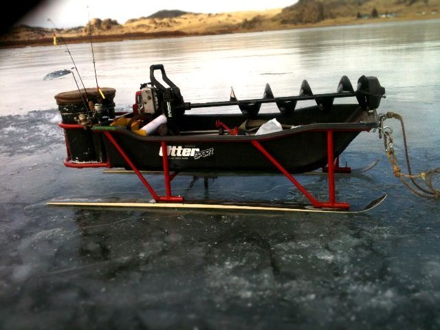 a small boat is sitting on the ice with two fishing rods attached to it's front end