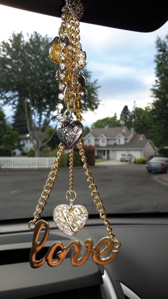 a car dashboard with a chain hanging from it's center console and the word love written in gold