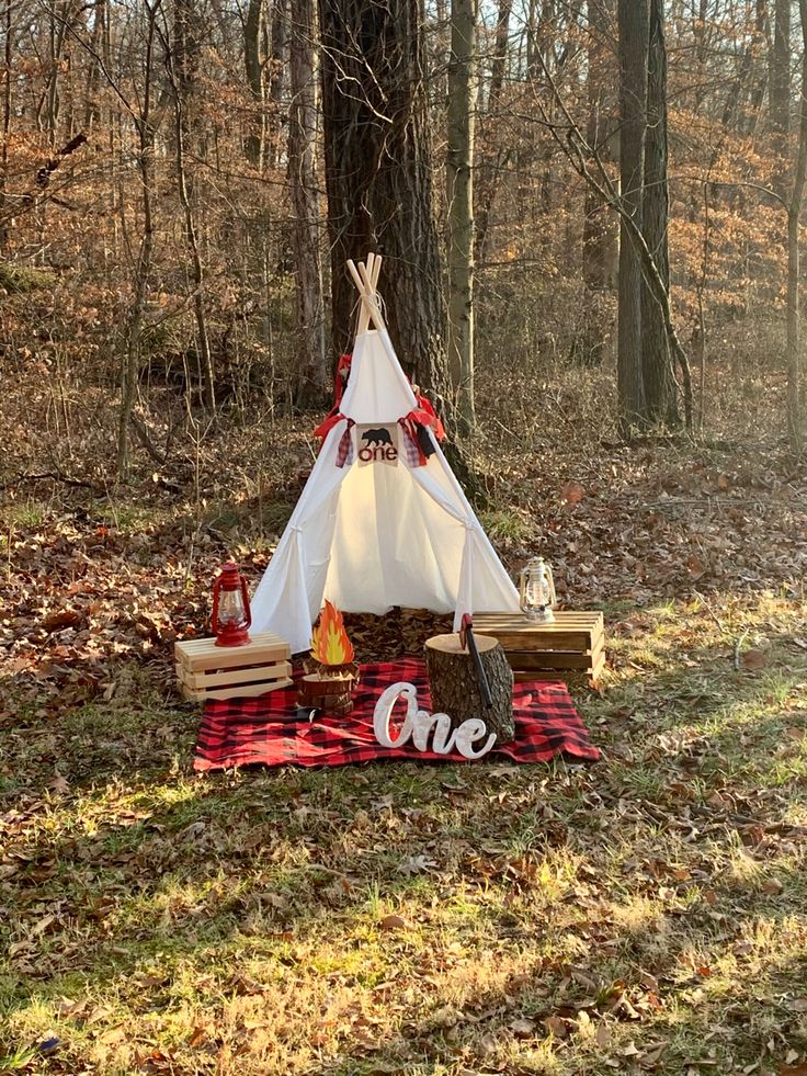 a teepee sitting in the middle of a forest with one sign on it's side