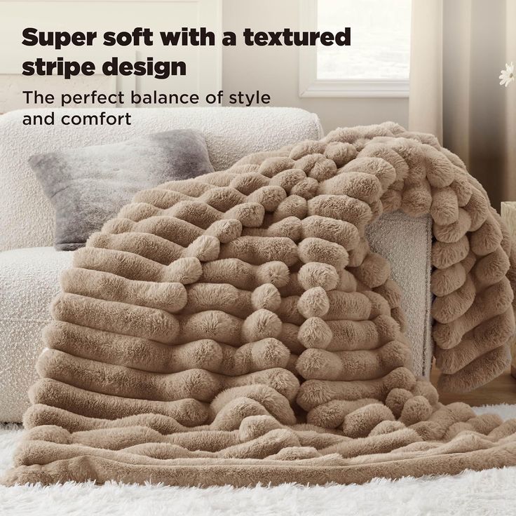 a large pile of blankets sitting on top of a white rug next to a couch