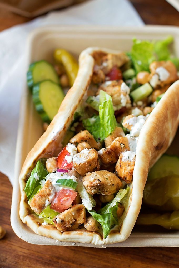 two pita sandwiches with chicken, lettuce and tomatoes